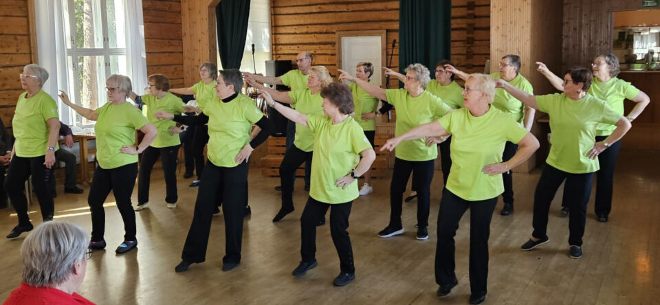 Iso ryhmä vihreäpaitaisia esittämässä tanssia